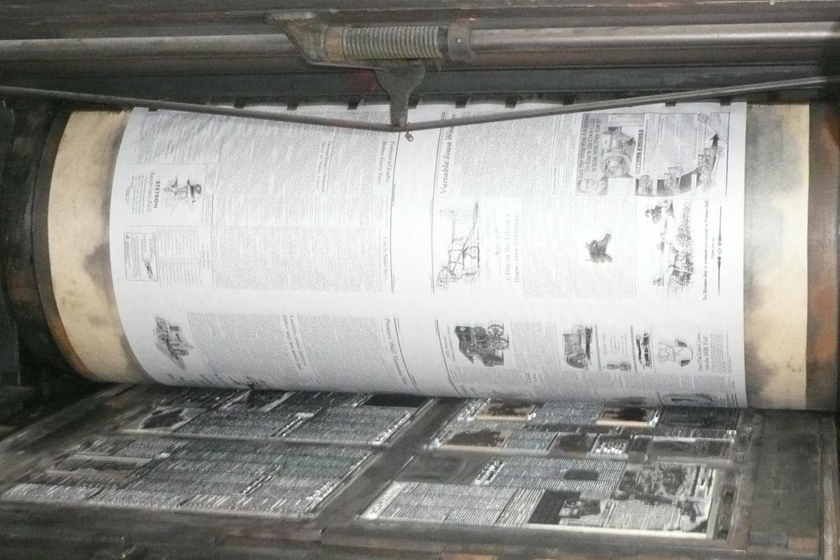 A newspaper page on the cylinder of an old letterpress printing machine